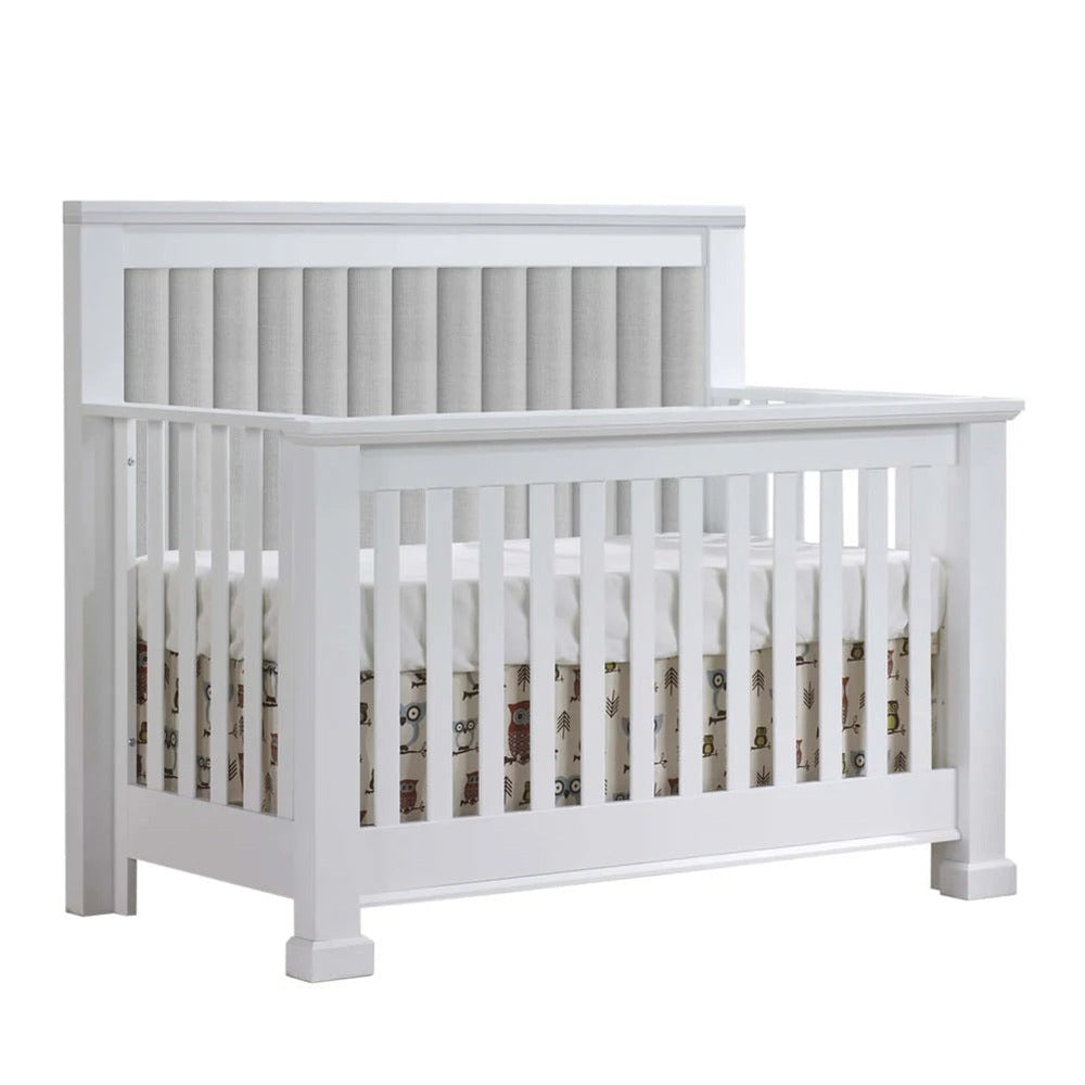 Natart Taylor 5-in-1 Convertible Crib in white with channel-tufted headboard panel.