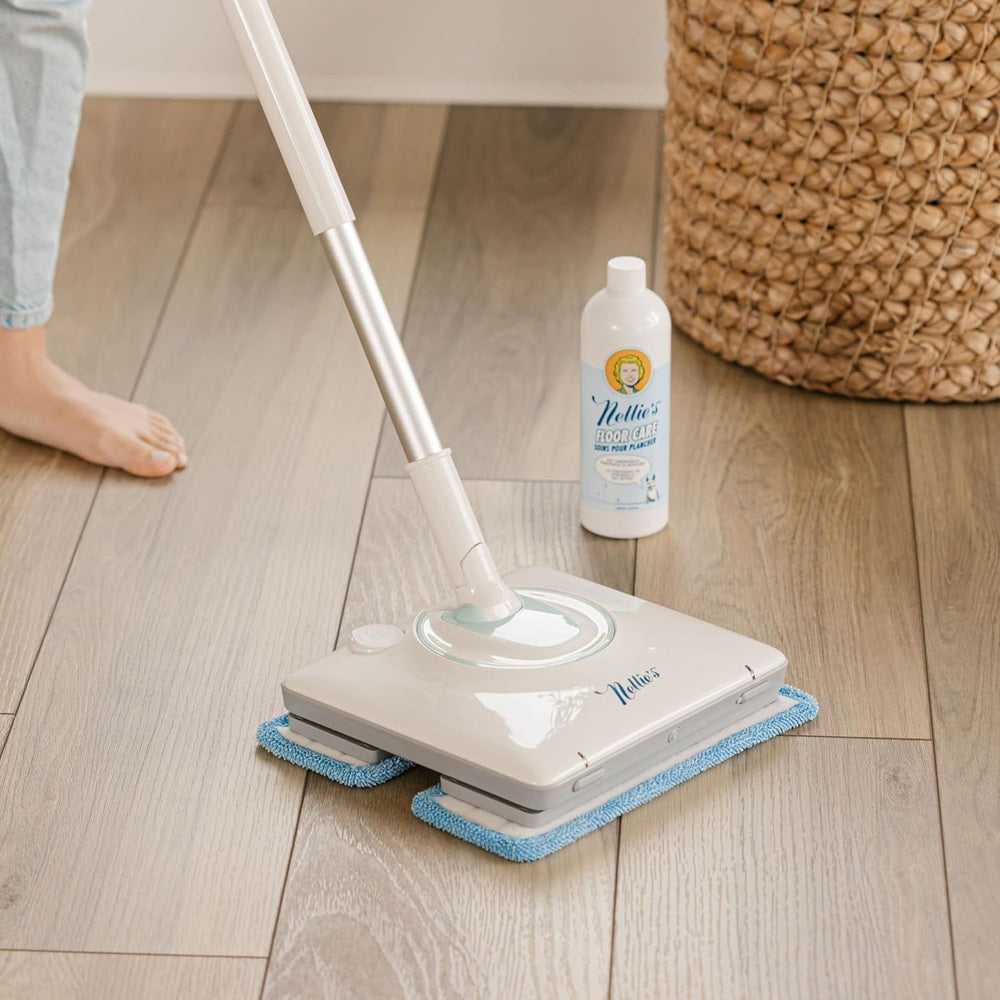 Nellie's Wow Mop gliding over light hardwood floor with blue microfiber pads attached.