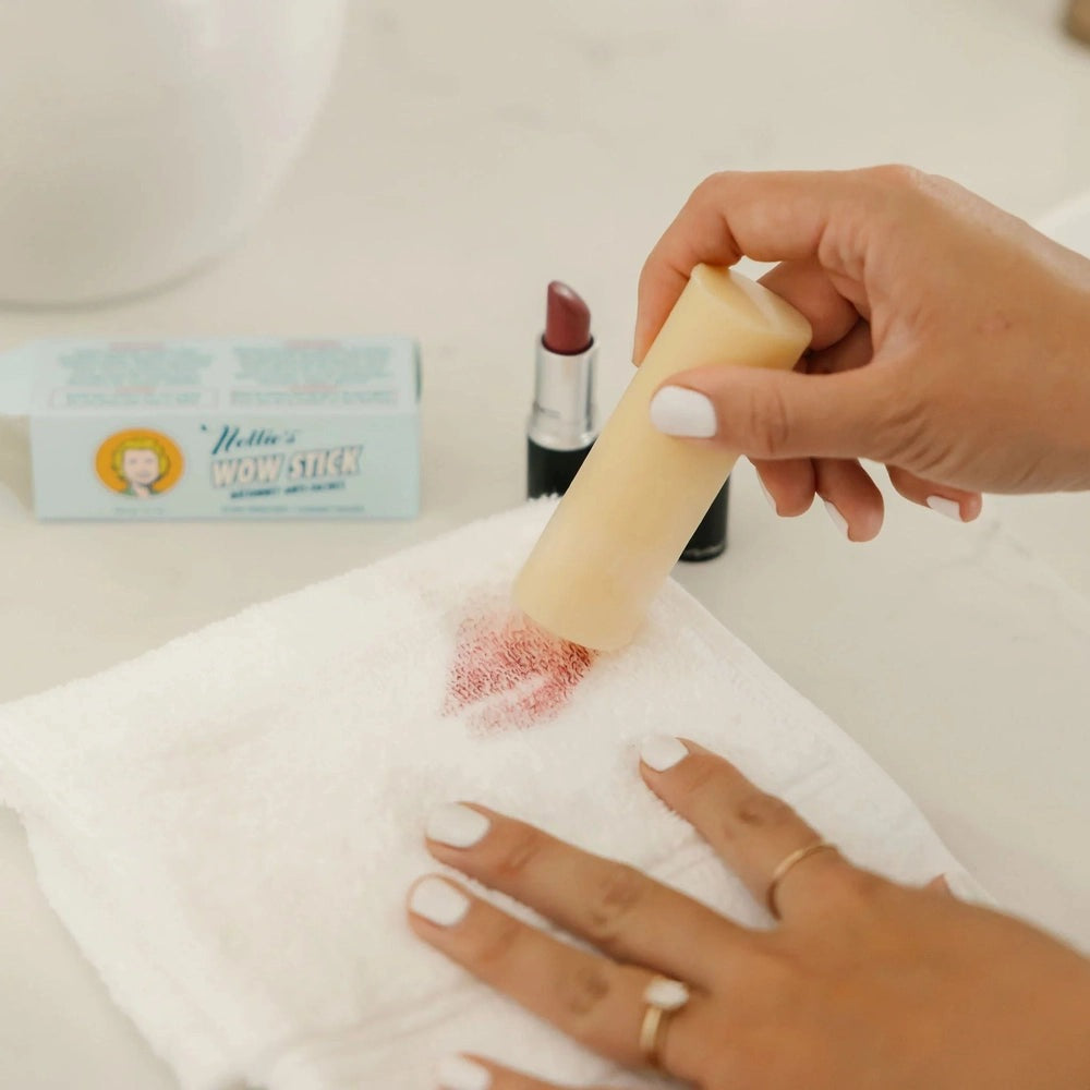 Nellie's Wow Stick Stain Remover with beige applicator erases lipstick stain from white towel.