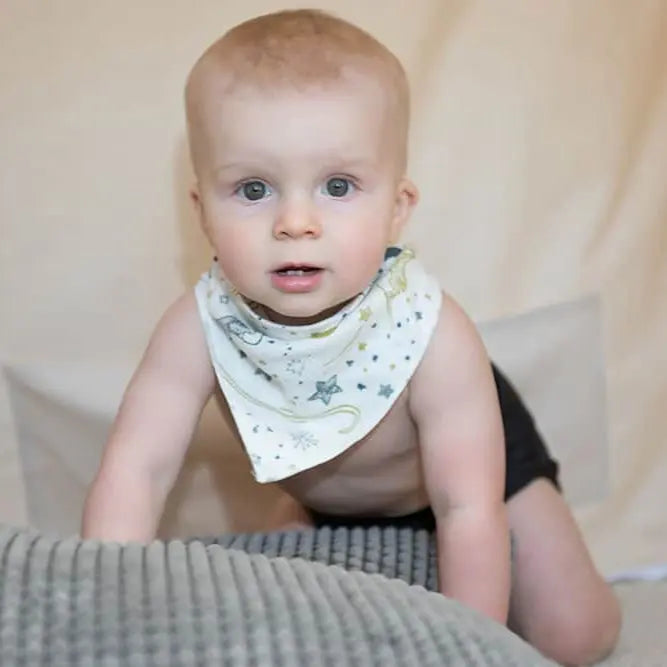 Nest Designs Bamboo Baby Bandana Bib One Size (3M-24M) white star-print worn by crawling baby.