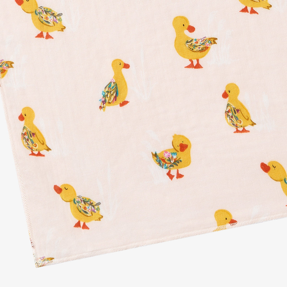 Close-up of cream Flights Of Fancy washcloth with yellow ducks and floral-patterned wings.
