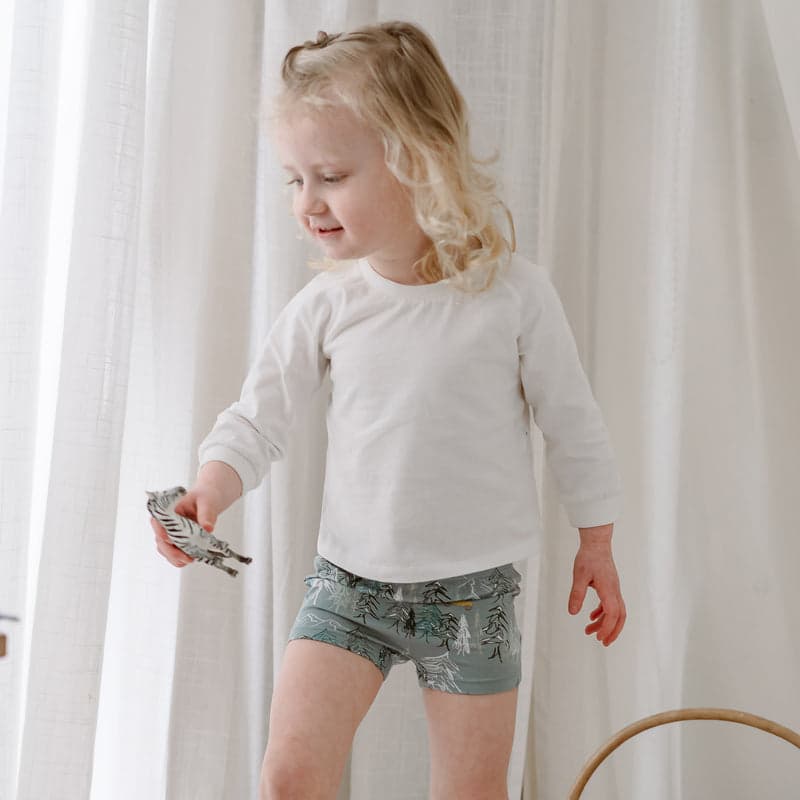 Nest Designs Bamboo Girls Boy Short Underwear (2 Pack) Forest Fun: toddler in forest-print bamboo shorts, playing indoors.