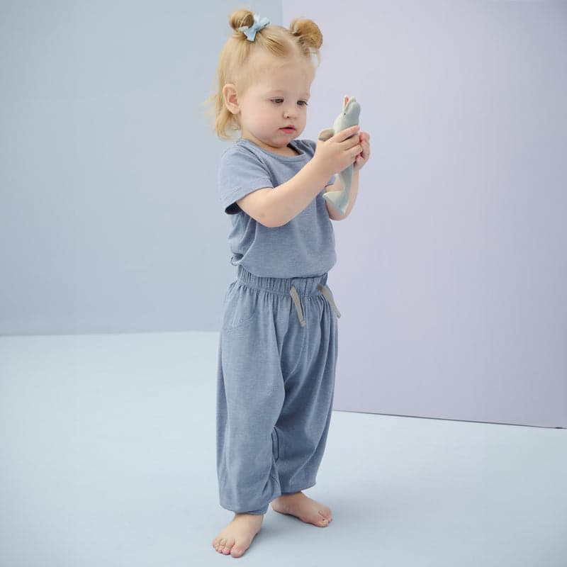 Nest Designs Bamboo Jersey Harem Pants Troposphere: toddler in soft blue-gray pants holds a plush toy.