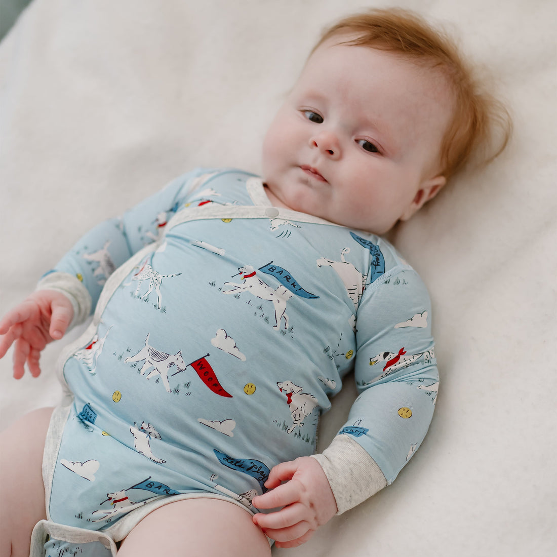 Baby resting in the Puppy Park Long Sleeve Onesie