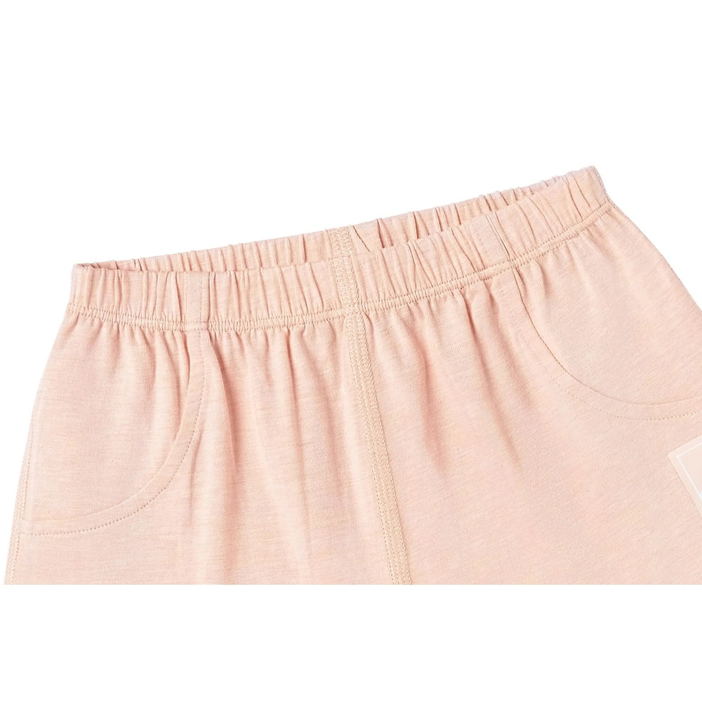 Nest Designs Bamboo Jersey Shorts Pantone Bellini in peach, elastic waistband shown with soft drape and curved pockets.