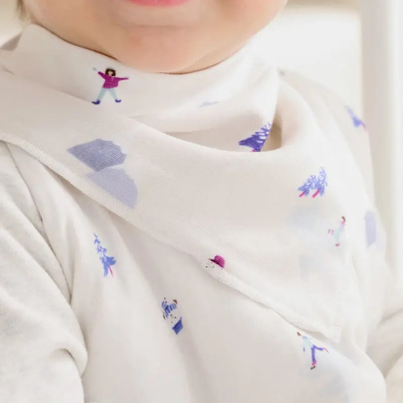 Nest Designs Bamboo Muslin Baby Bandana Bib Frosty Fun, white bib with playful blue and pink prints on a baby.