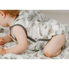 Nest Designs Bamboo Pima sleeveless button-down baby onesie in jungle stripes, worn by a crawling baby.