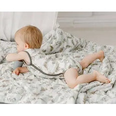 Nest Designs Bamboo Pima Sleeveless Button-Down Onesie Jungle Stripes worn by a crawling baby on a soft bed.