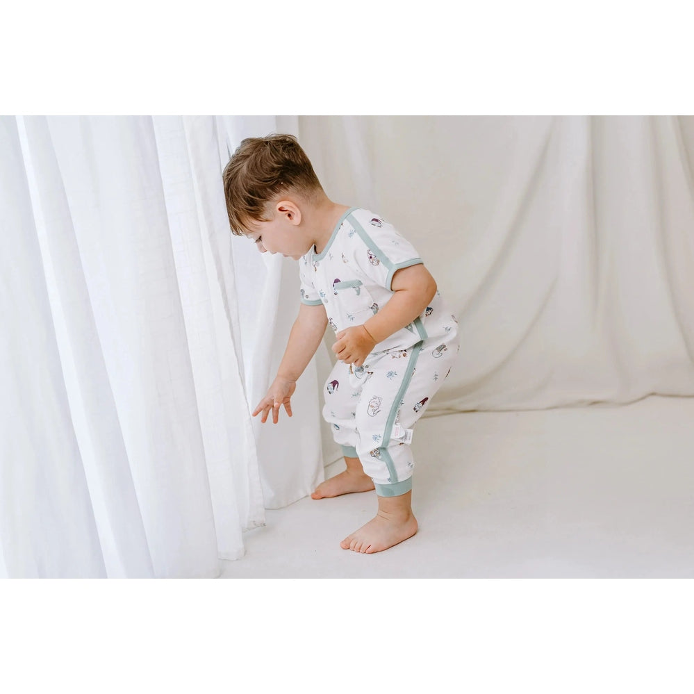 Nest Designs Bamboo Short Sleeve Romper Oh Gnome, white with pale blue trim, toddler reaches toward a curtain