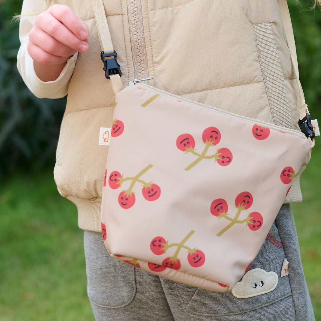 Nest Designs Biscuits and Vine waterproof bag in You're So Vine blush worn crossbody over a beige vest outdoors