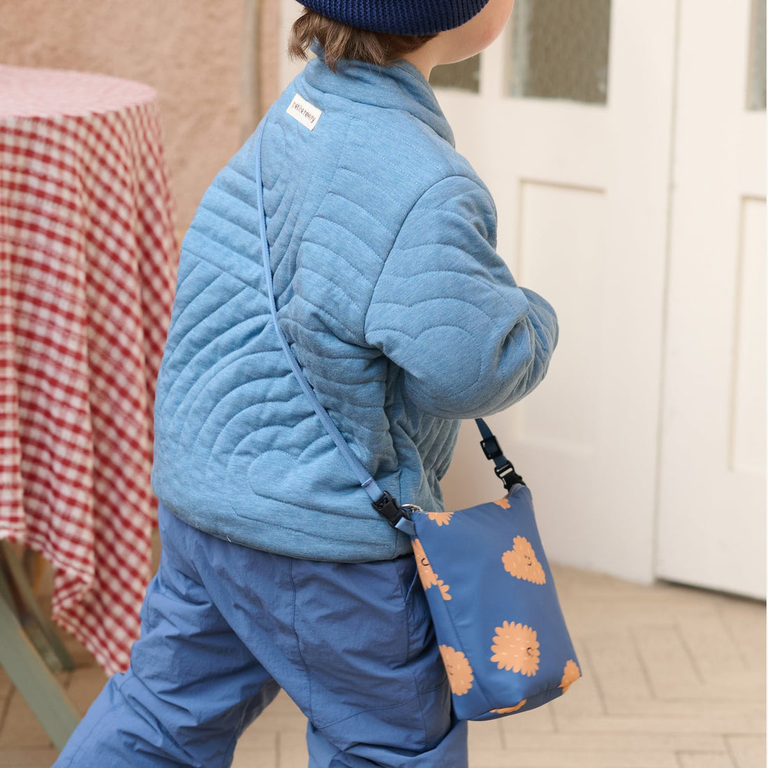 Nest Designs Biscuits and Vine waterproof bag in Biscuit Banter navy hanging behind a child's hip in a rear walking view