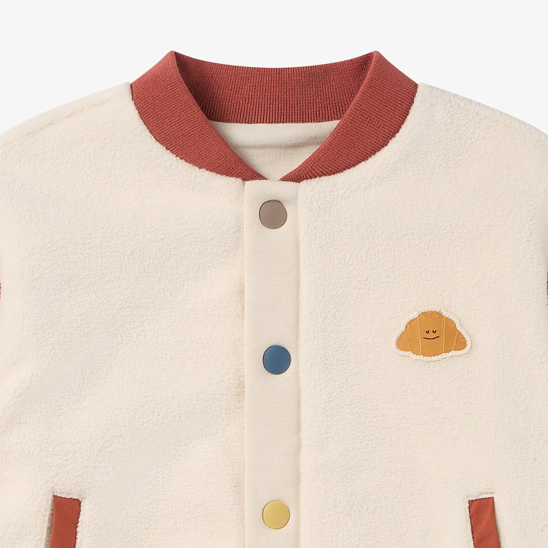 Nest Designs Redwood Burl Cozy Croissant Fleece Jacket neckline detail with rust collar, cream fleece and croissant chest patch