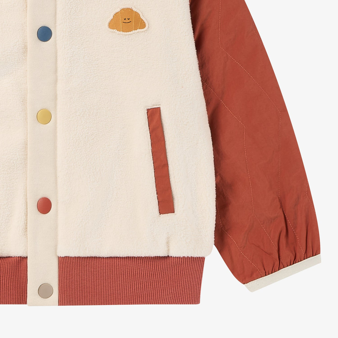 Nest Designs Redwood Burl Cozy Croissant Fleece Jacket lower detail showing the rust pocket trim, quilted sleeve and multicolour placket