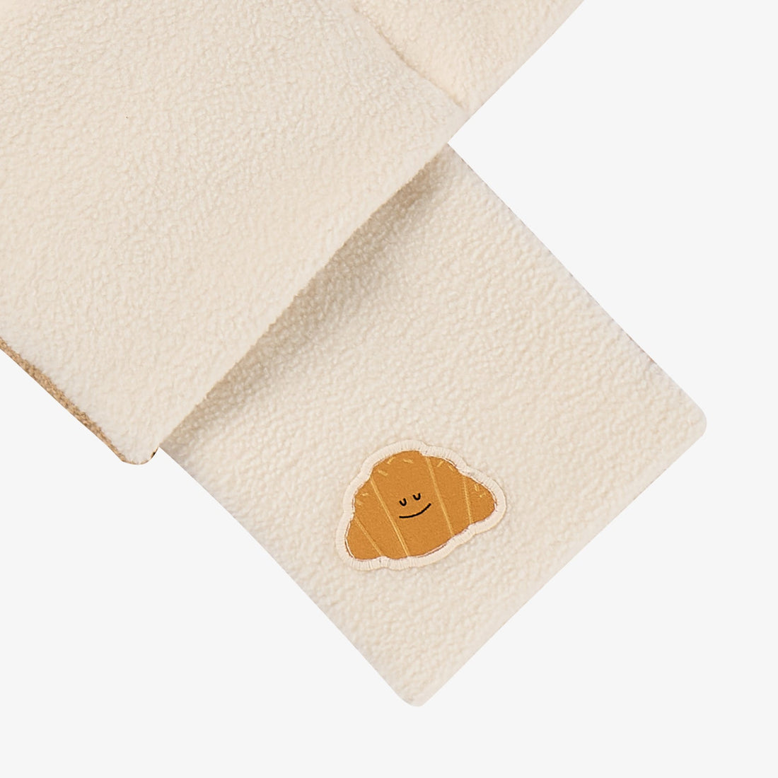 Nest Designs Cozy Croissant reversible scarf in Cloud cream, crossed-end detail highlighting the croissant patch