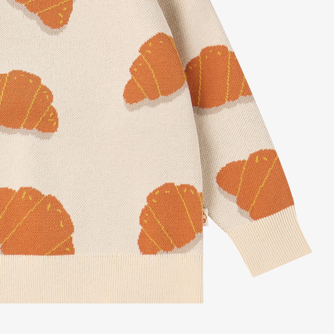 Nest Designs Cozy Croissants cream knit sweater, lower detail of patterned sleeve, ribbed cuff, and hem