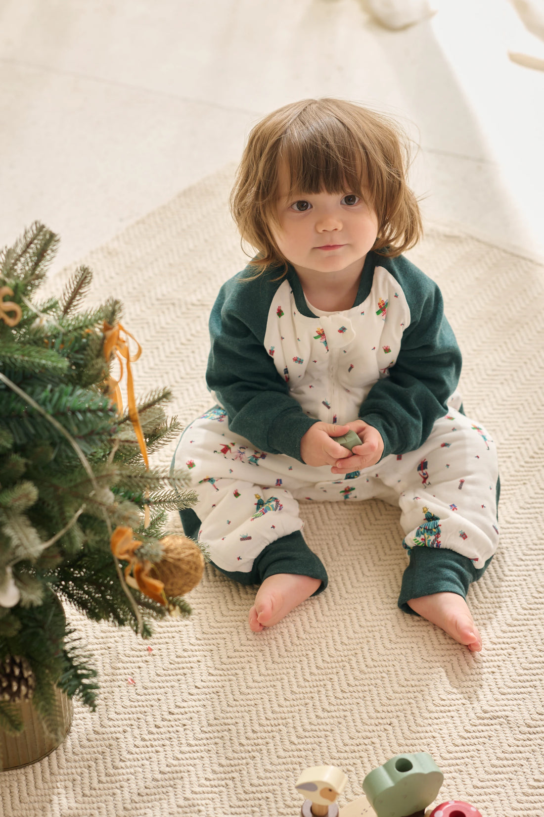 Nest Designs Santas Elves: child seated on a floor showing the sleep bag separate cuffed legs
