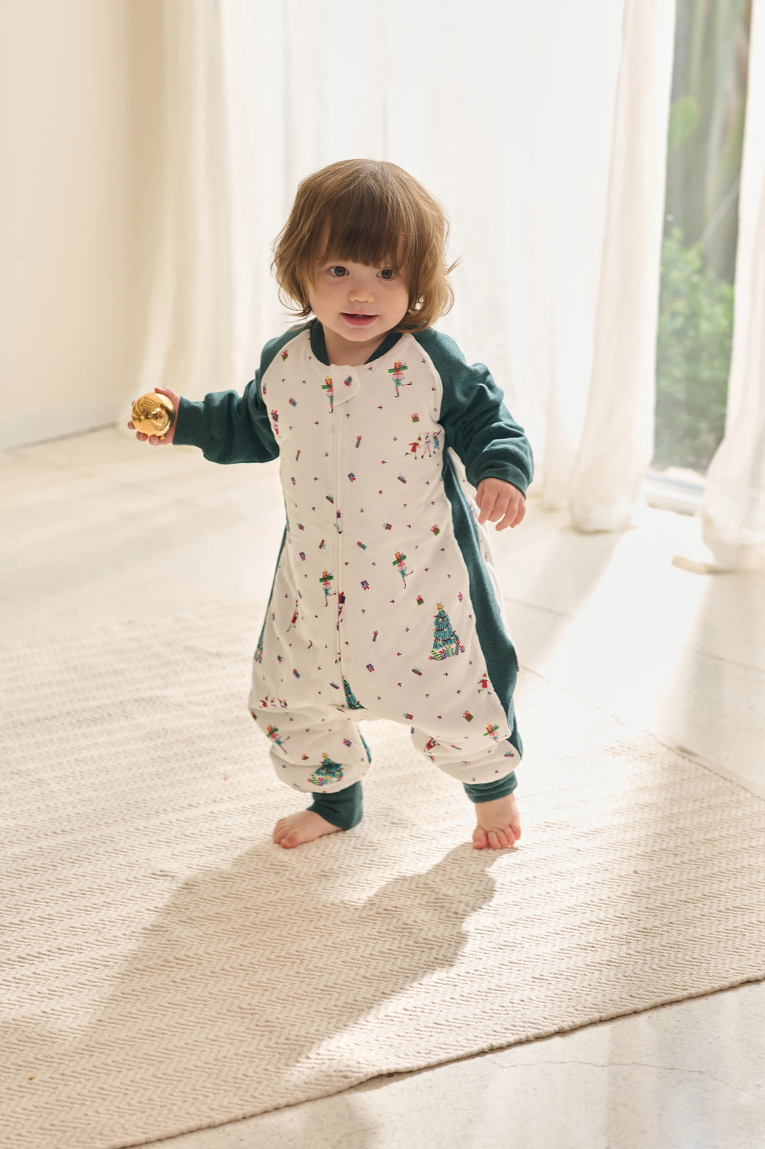 Nest Designs Santas Elves: child standing in the green-sleeve 2.5 TOG sleep bag with separate cuffed legs