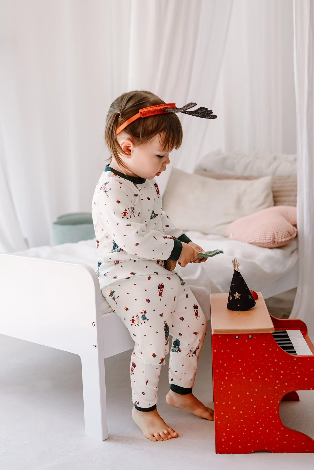 Nest Designs Santas Elves: side view of a child playing in the matching pajama top and pants