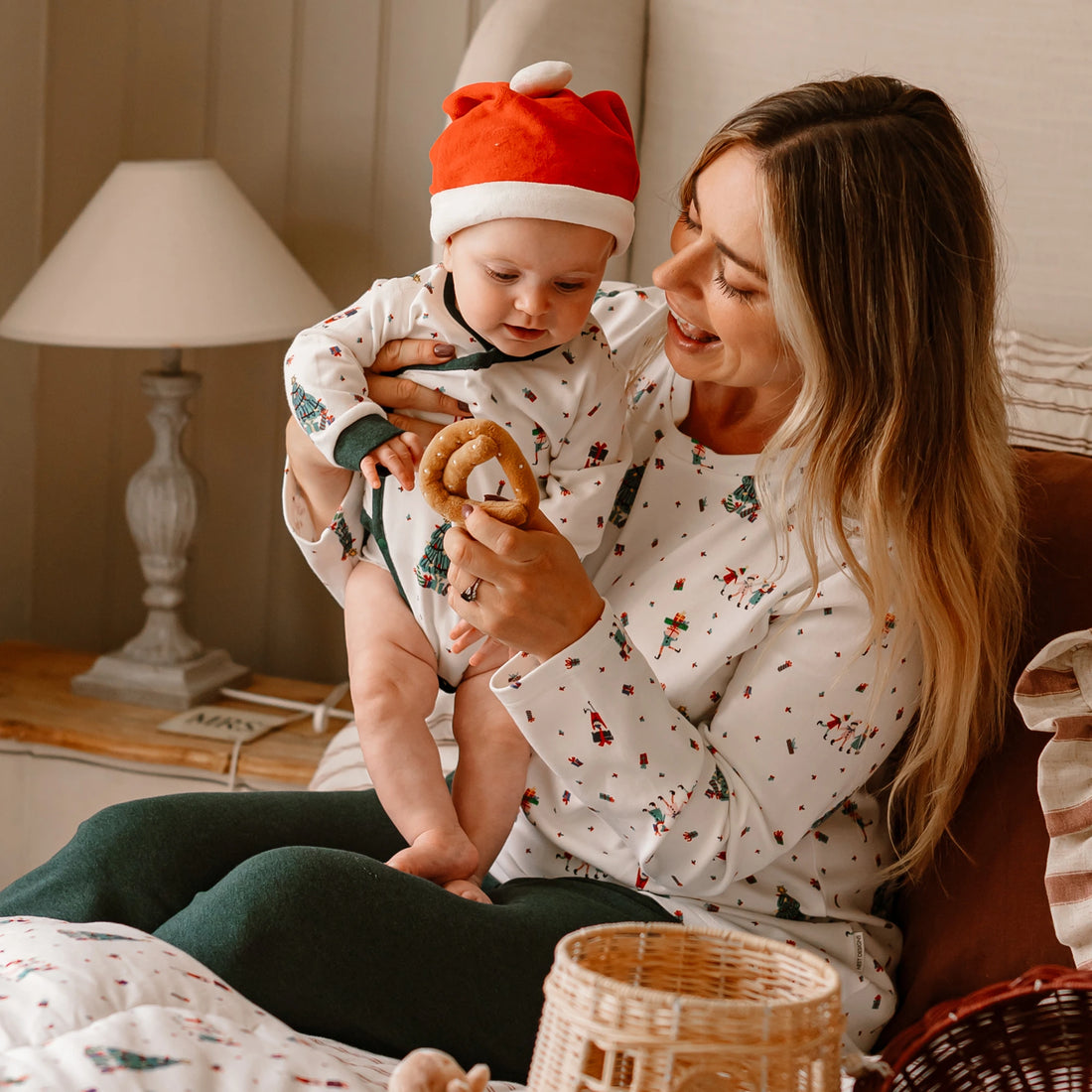 Nest Designs Santas Elves: caregiver holding a baby in the kimono onesie with a separate holiday hat