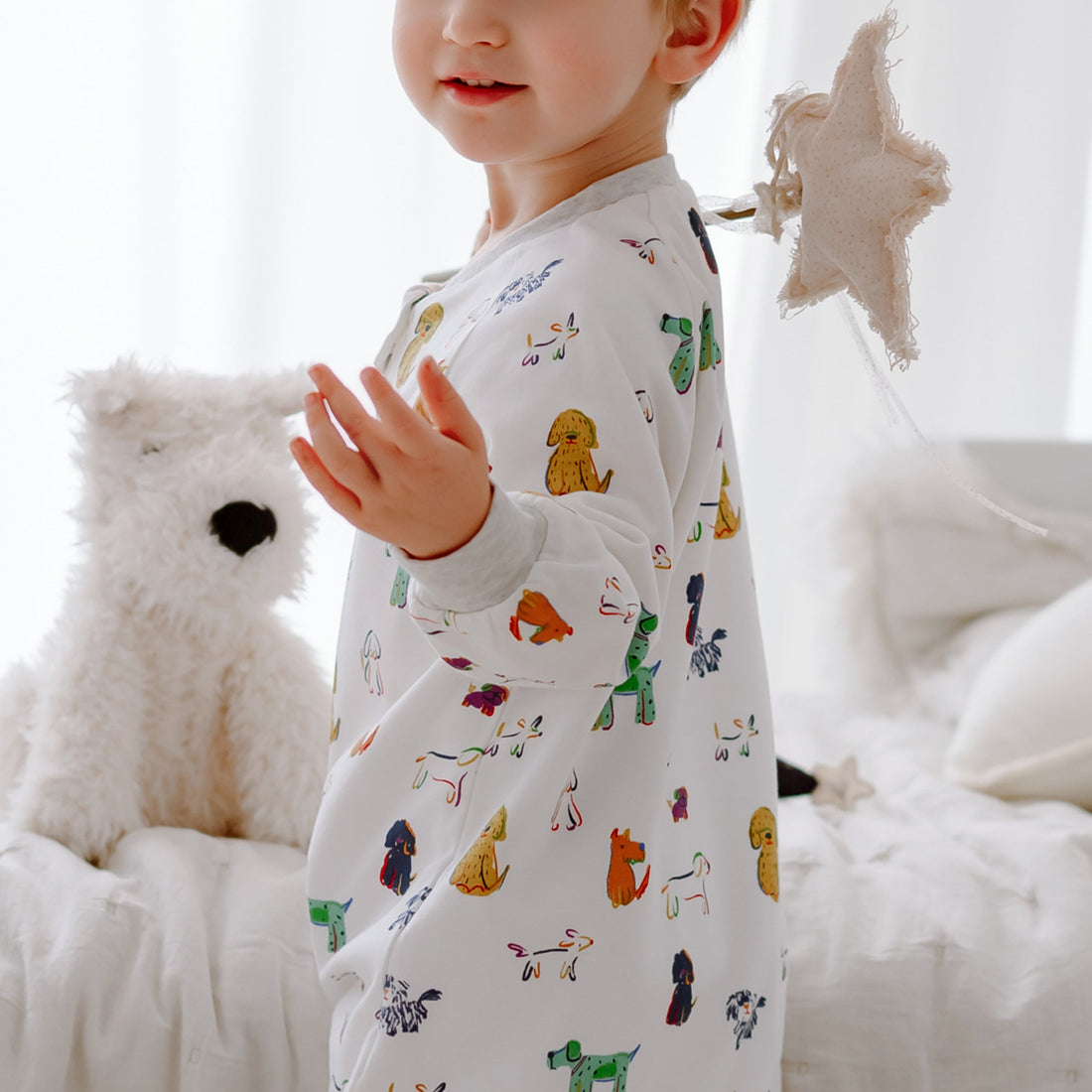 Nest Designs Bingo 1.0 TOG footed sleep bag lifestyle view highlighting the colourful dog print