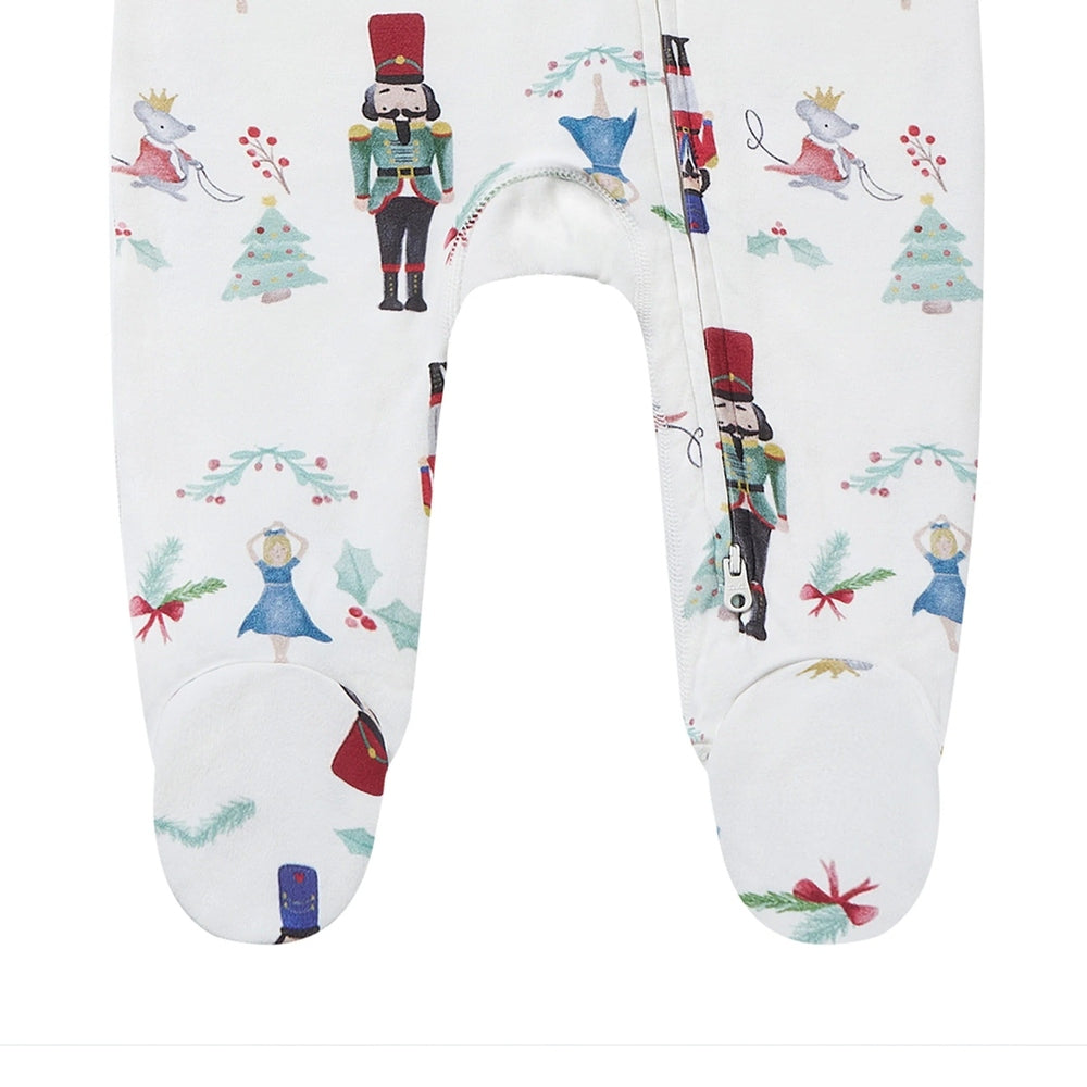 Nest Designs Organic Cotton Long Sleeve Footed Sleeper Nutcracker worn by toddler in festive white print with side zipper.