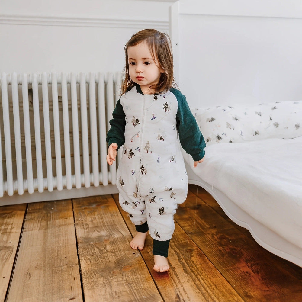 Nest Designs Raglan Bamboo Long Sleeve Footed Sleep Bag 2.5 Tog, white with tree print, toddler walking indoors