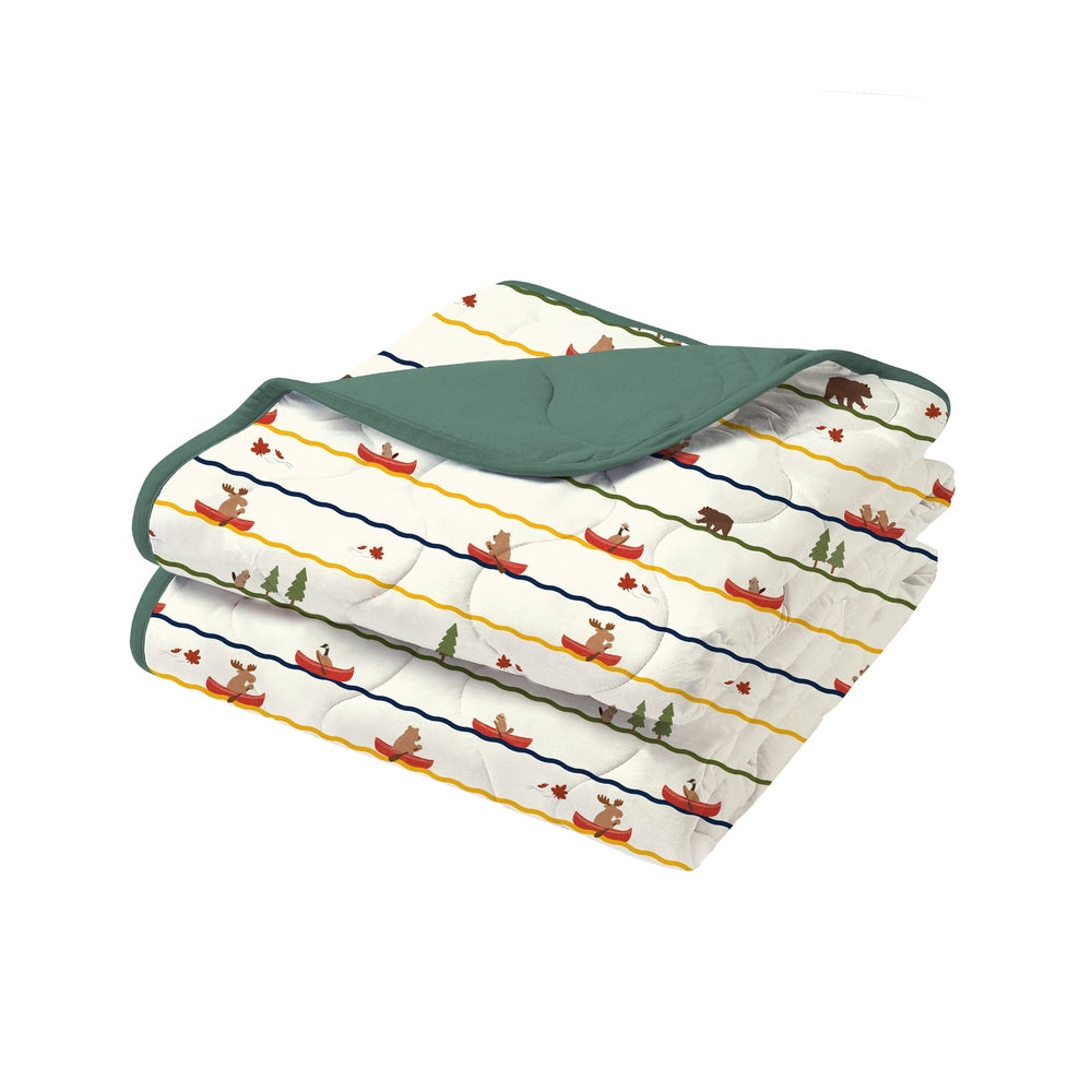 Nest Designs Small Cozy Blanket, white with colorful striped moose-and-tree pattern, folded to reveal green reverse side.