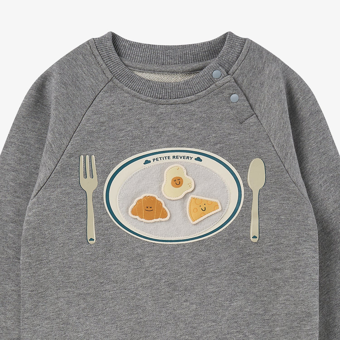 Nest Designs Smiley Plate Velcro Sweatshirt in Pebble Grey, upper-front detail of ribbed neck, snap shoulder, and food plate