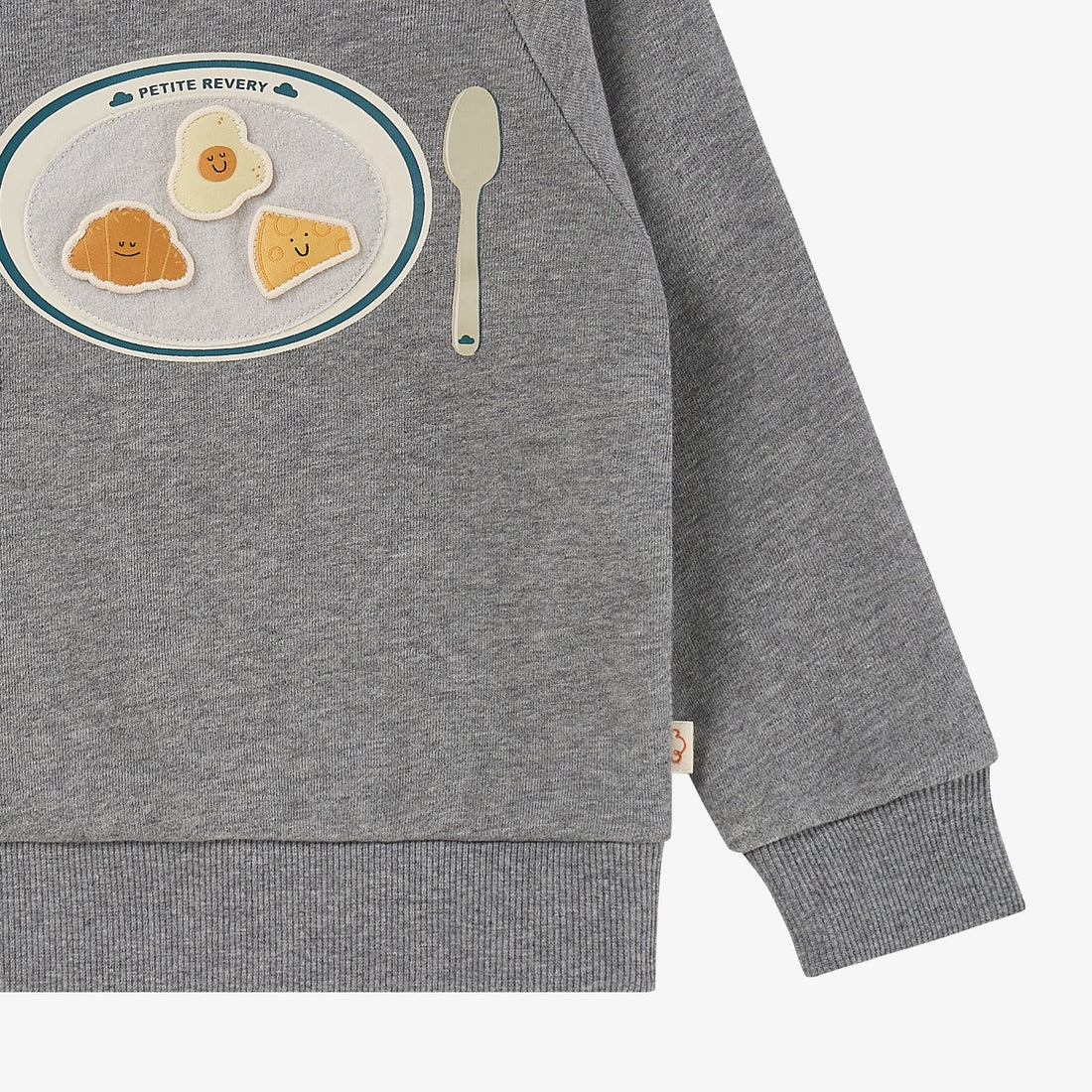 Nest Designs Smiley Plate Velcro Sweatshirt in Pebble Grey, lower-front detail with spoon, cuff, and ribbed hem