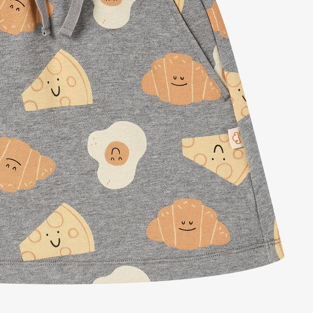 Nest Designs Smiley Side Up grey skirt, lower-panel detail with straight hem, side seam, and smiling food characters
