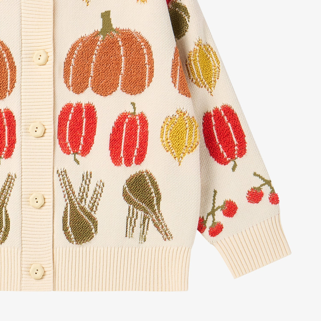 Nest Designs Veggie Jacquard Cardigan in Veggie Tales cream, lower detail with peppers, leeks, cherries, hem, and cuff