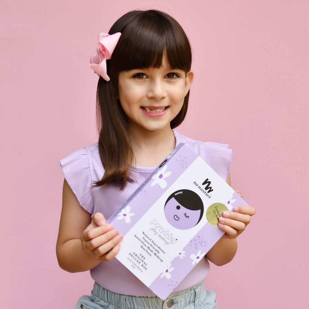 No Nasties Kids Nancy purple natural pressed powder makeup palette kit held by a smiling girl