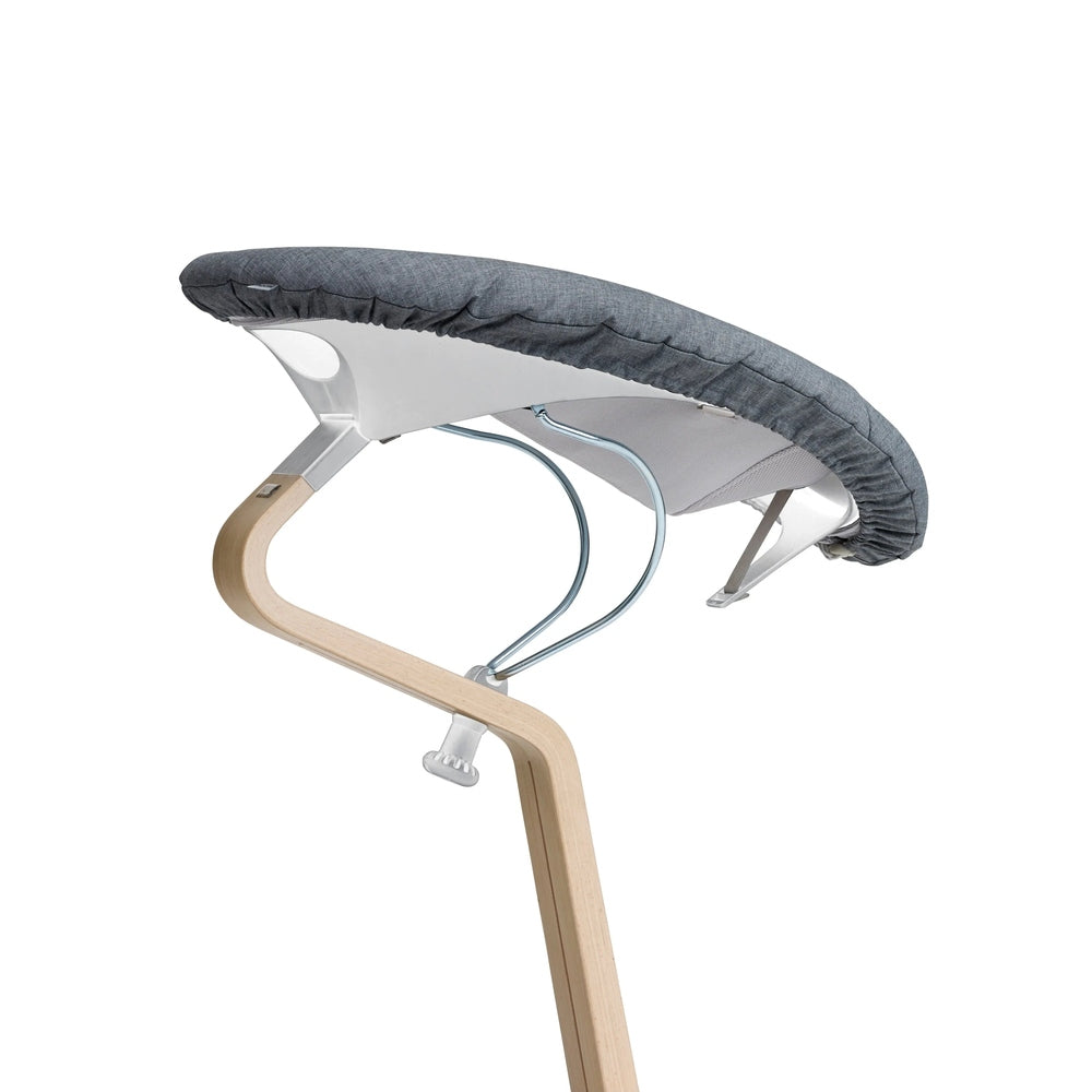 Nomi Baby high chair cushion in gray fabric, attached to the curved wooden frame with metal supports.