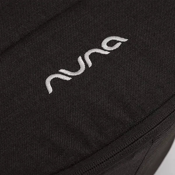 Nuna DEMI Next Bassinet showing Close-up of embroidered Nuna logo and zipper seam on Caviar fabric