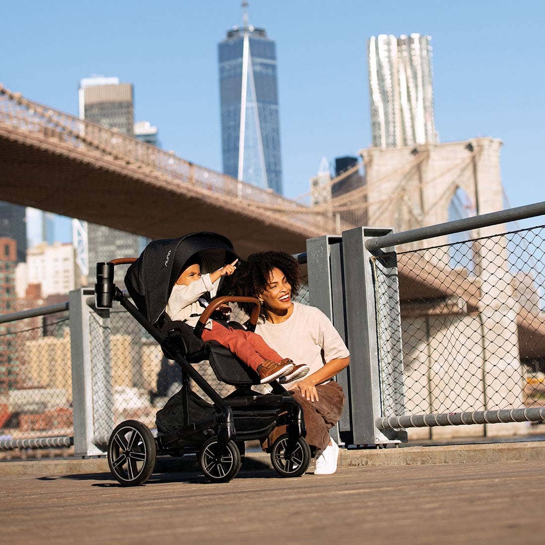 Nuna MIXX next Stroller — parent crouching beside child in stroller outdoors