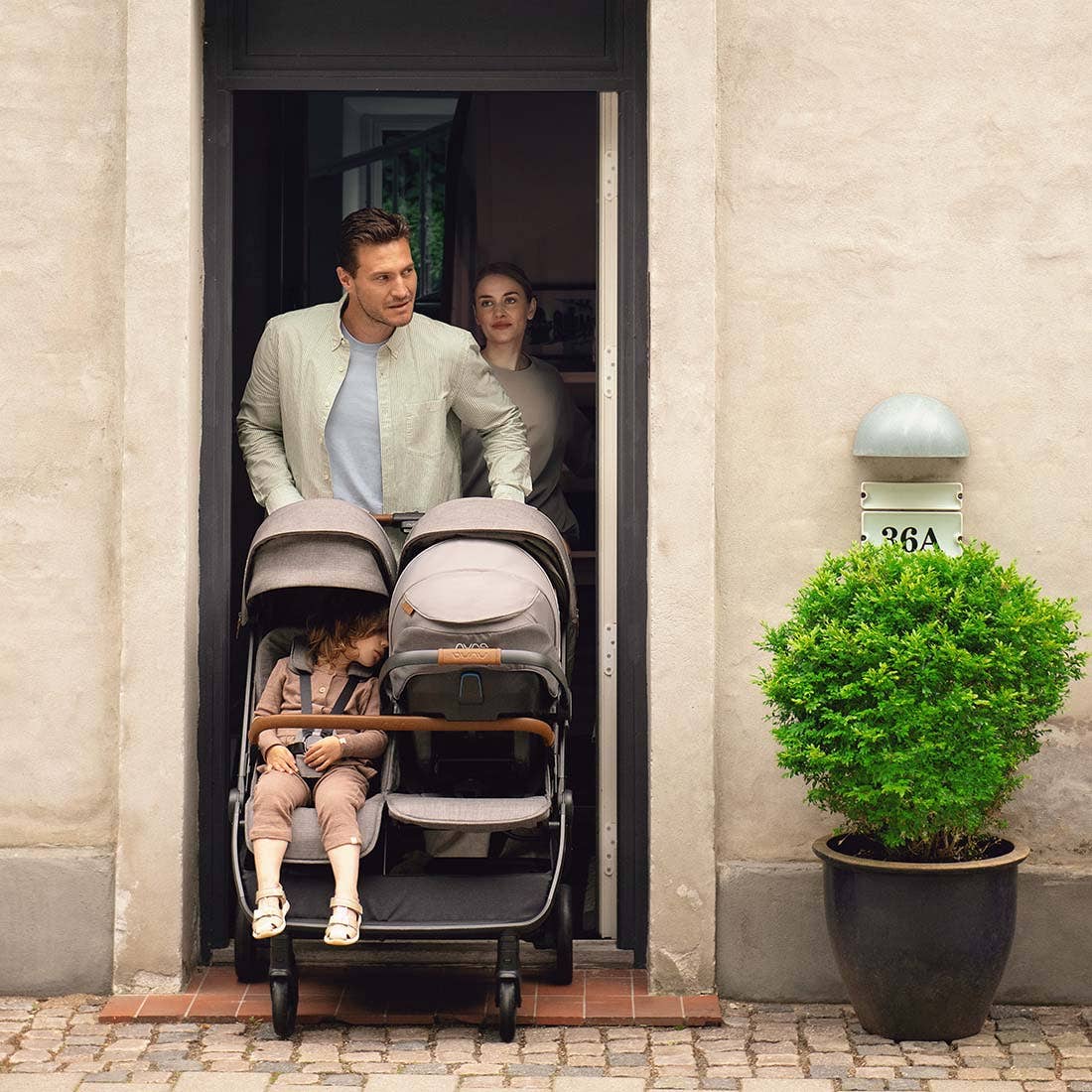 Nuna TRVL dubl Stroller — family passing through a doorway