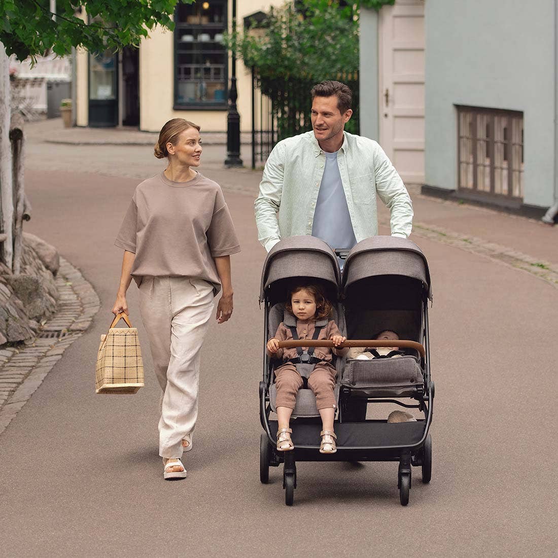 Nuna TRVL dubl Stroller — family pushing stroller on a city street