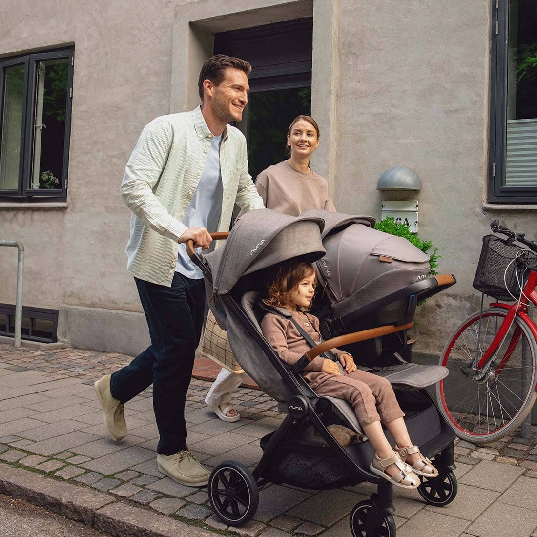 Nuna TRVL dubl Stroller — parent turning stroller on a cobblestone street