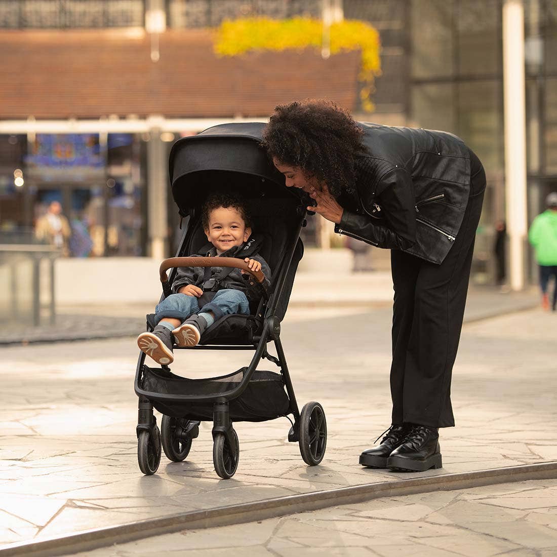 Nuna TRVL lx Stroller — parent greeting child from stroller front