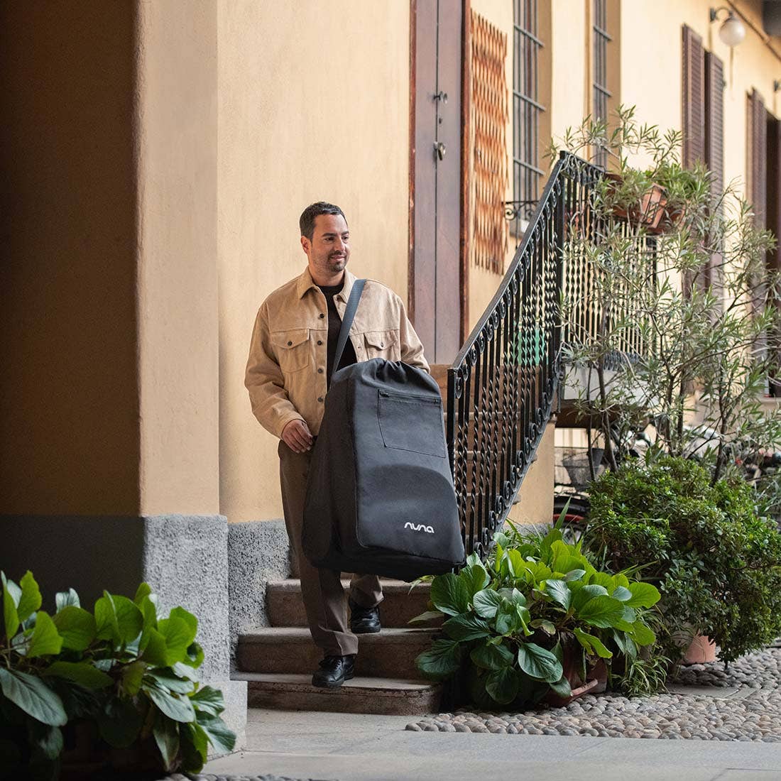 Nuna TRVL lx Stroller — traveller carrying folded stroller in bag