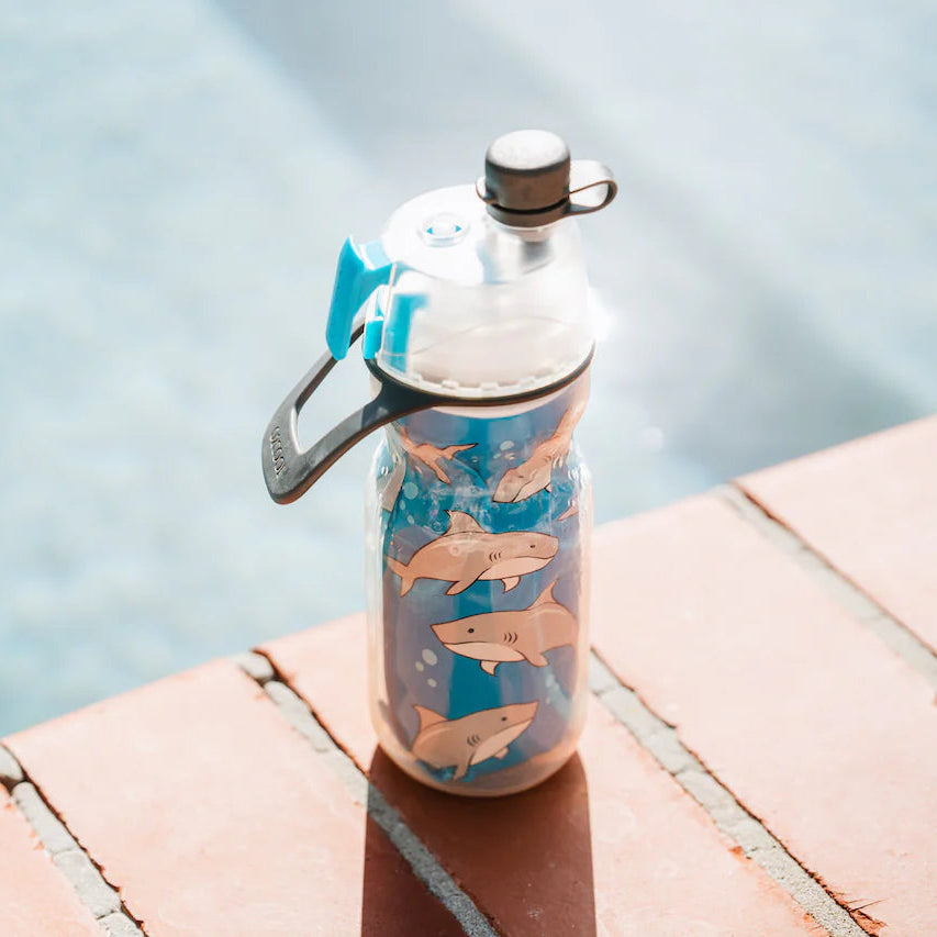 Reusable water bottle with fish design on a ledge by a pool
