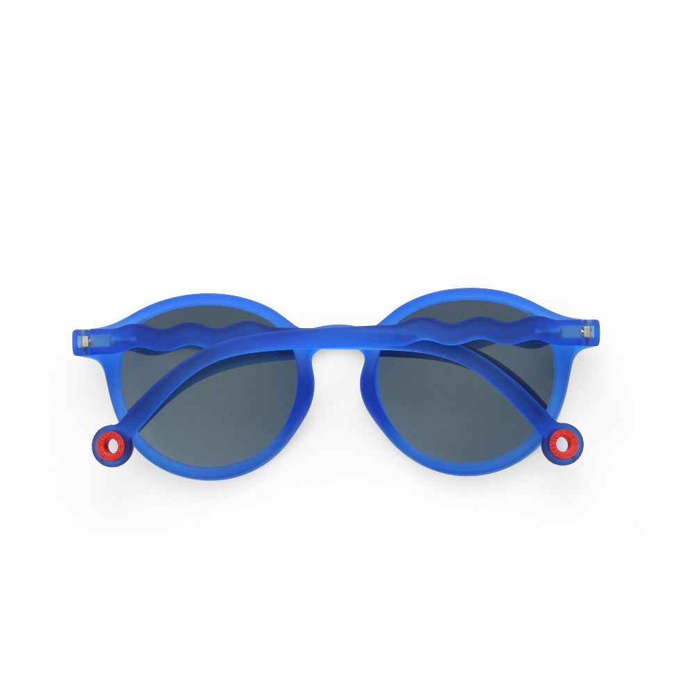 Olivio & Co Oval Sunglasses Kids/Junior Classic Olivio Chagall Blue, blue frame with gray lenses, laid flat showing red hinge accents