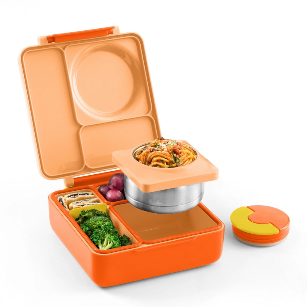 Omiebox Version 2 lunch container in orange with beige lid; metal insert holds pasta while separate compartments hold veggies.