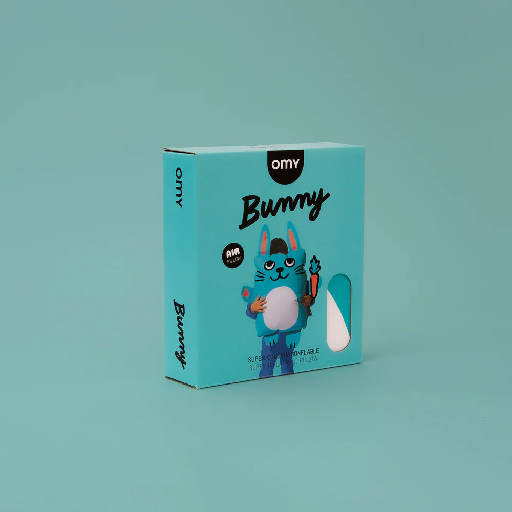 OMY Bunny super inflatable pillow in turquoise box showing a blue bunny holding a white pillow.