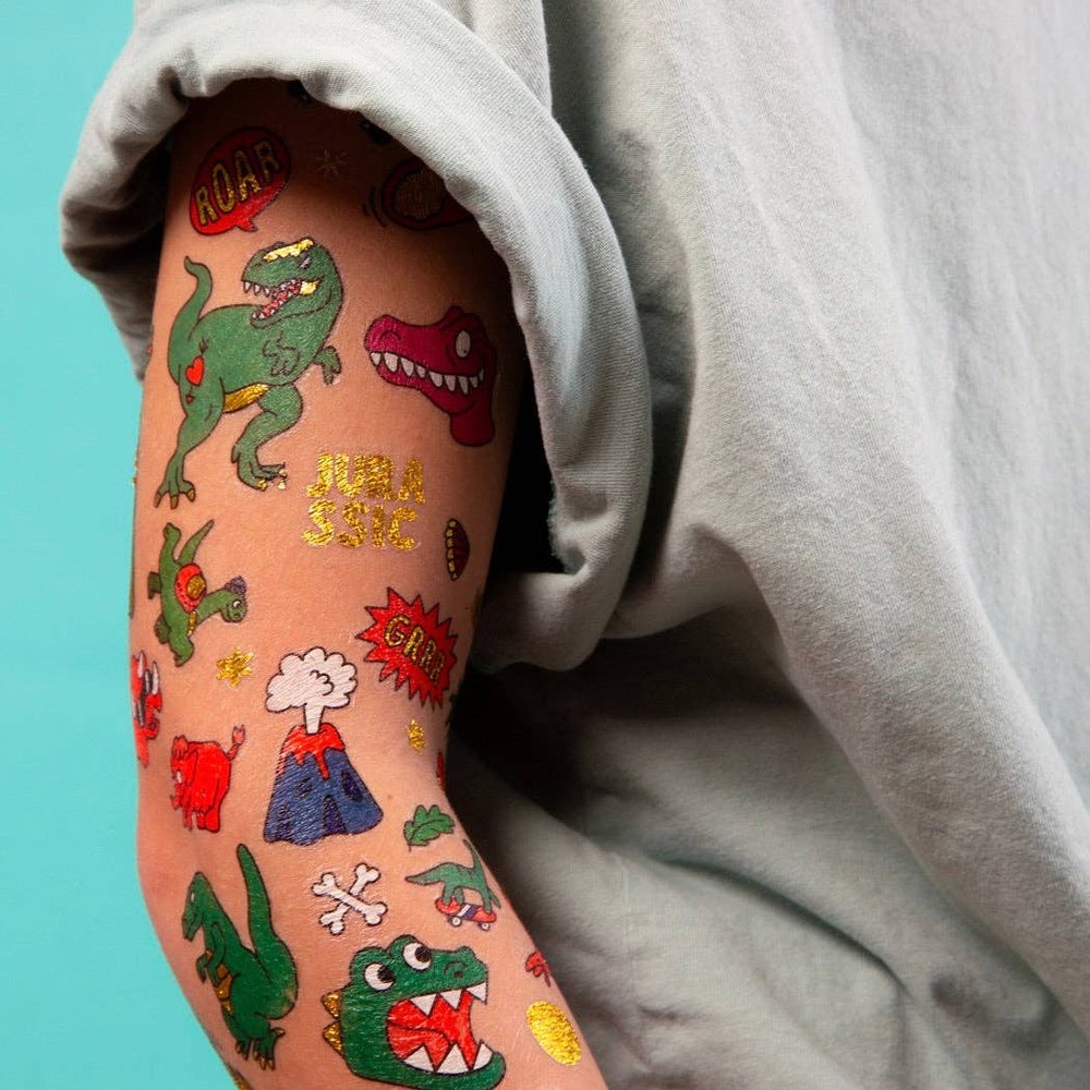 OMY Dinos Tattoos on a forearm, bright dinosaur stickers creating playful temporary body art.