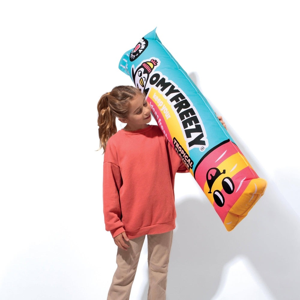 OMY Freezy giant inflatable pillow with turquoise/orange popsicle design, held aloft by a girl.
