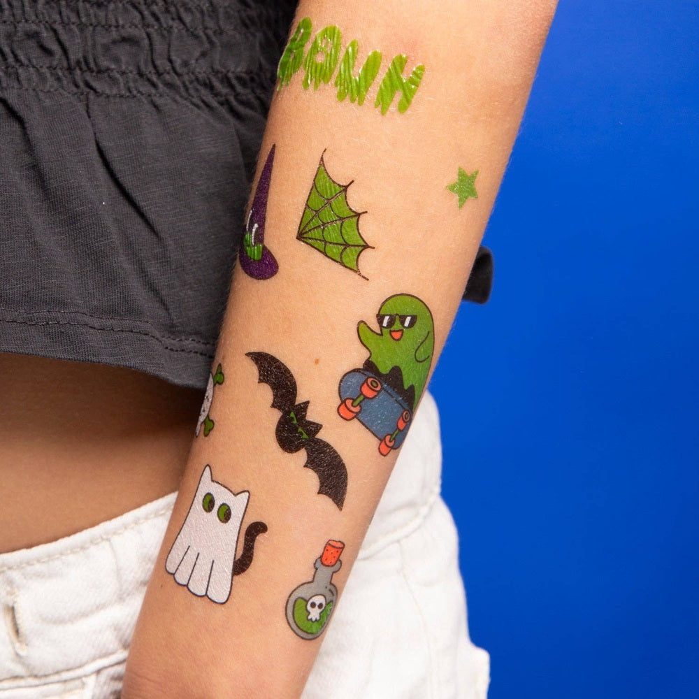 OMY - Glow in the dark - Tattoos on a forearm show playful Halloween designs, including a ghost, bats and cat.