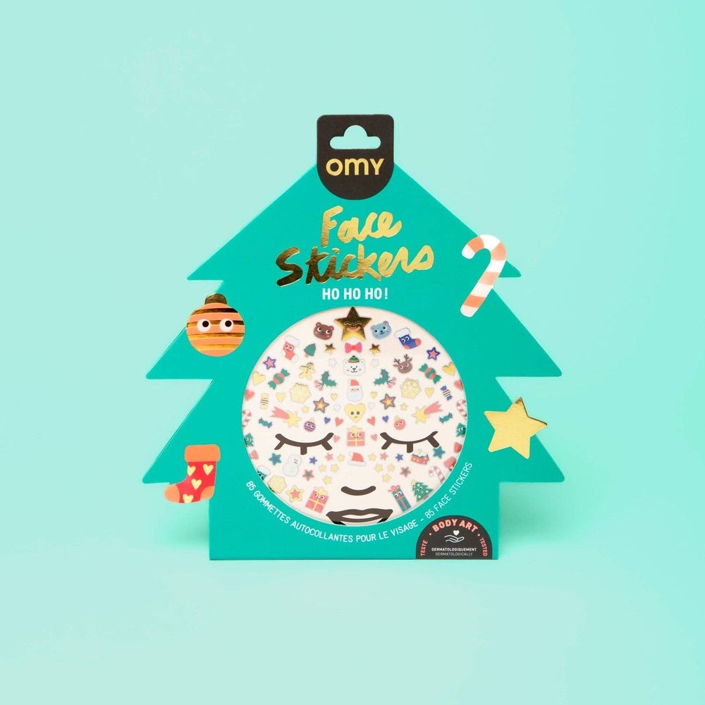 OMY Hohoho Holiday! Face stickers in teal tree packaging, round sheet filled with playful facial stickers.