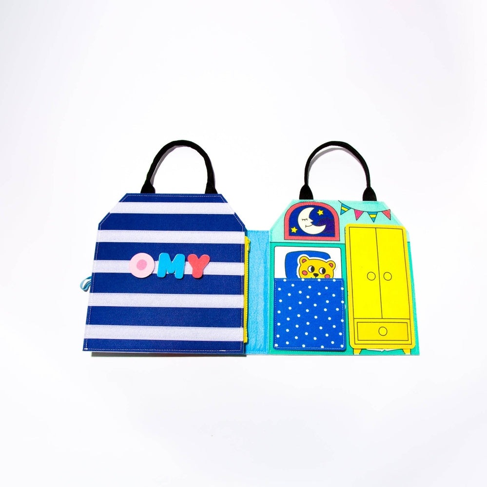 OMY Montessori Play Kit with blue striped cover and bright scene panels, fold-out pockets and handles.