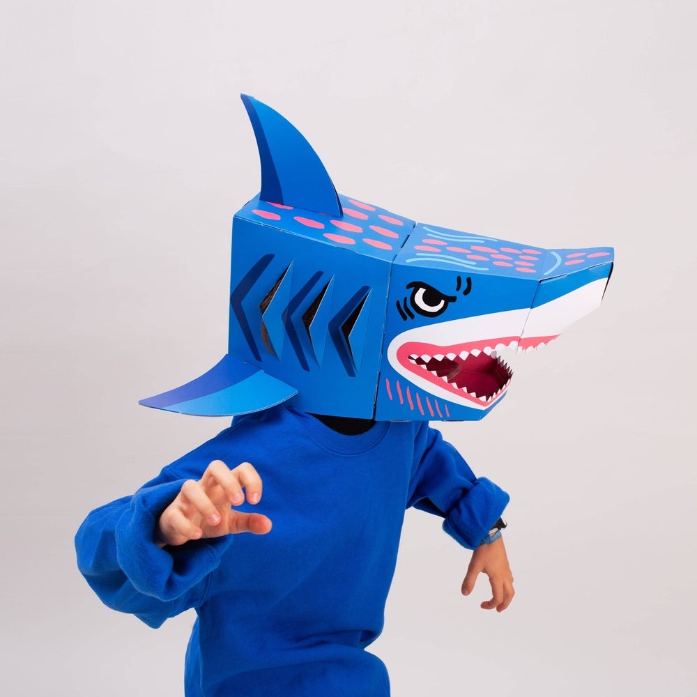 OMY Sharky 3D mask; blue shark head worn by a child in blue, posing as if lunging forward.